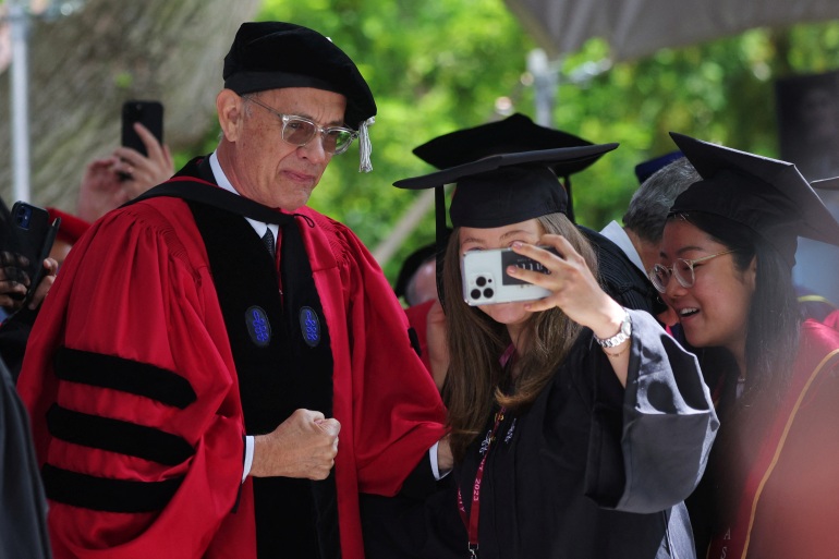Honorary degree recipient, actor Tom Hanks poses for a selfie with a graduating student during Harvard University’s 372nd Commencement Exercises in Cambridge, Massachusetts, U.S., May 25, 2023. REUTERS/Brian Snyder